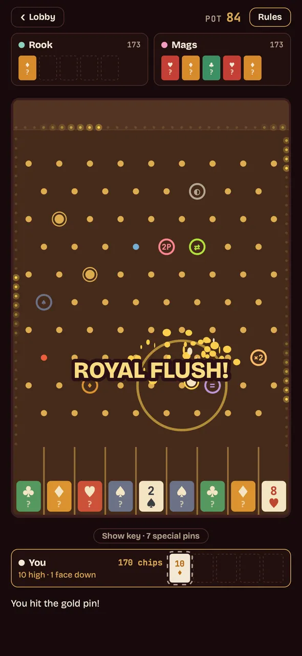 The moment of the hit: ROYAL FLUSH in gold over a burst of sparks where the ball struck the gold pin.